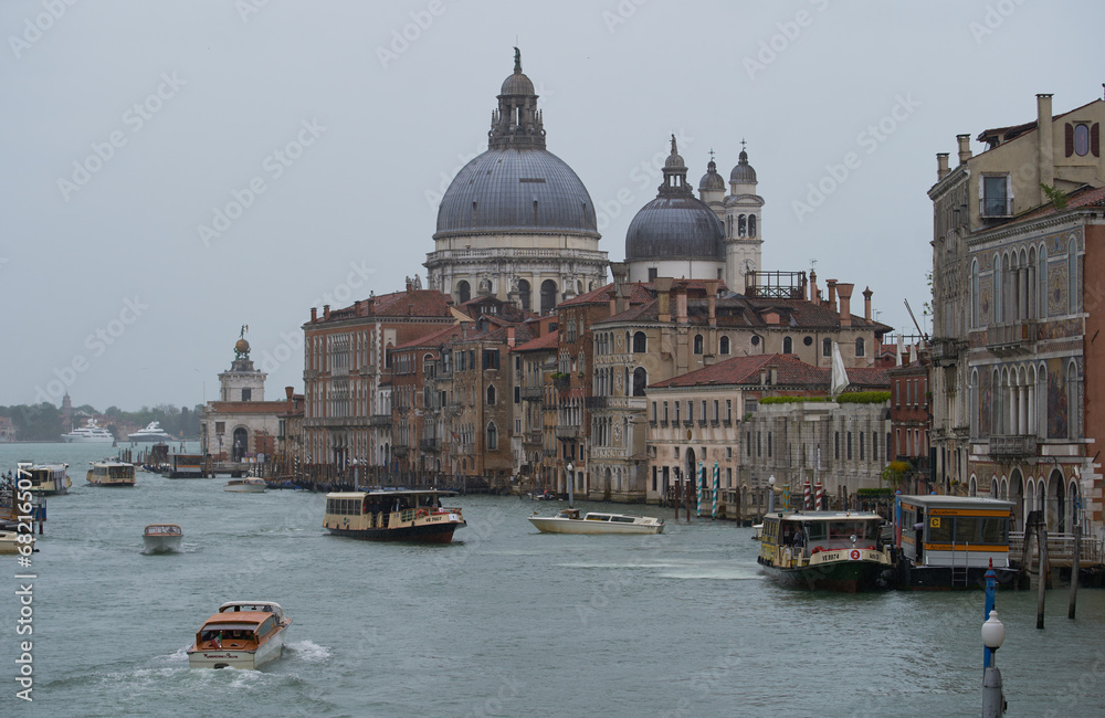 Church of Saint Mary of Health (Italian: Basilica di Santa Maria della Salute) and water taxis cruising in Grand Canal, view from Rialto bridge. Venice - 5 May,2019