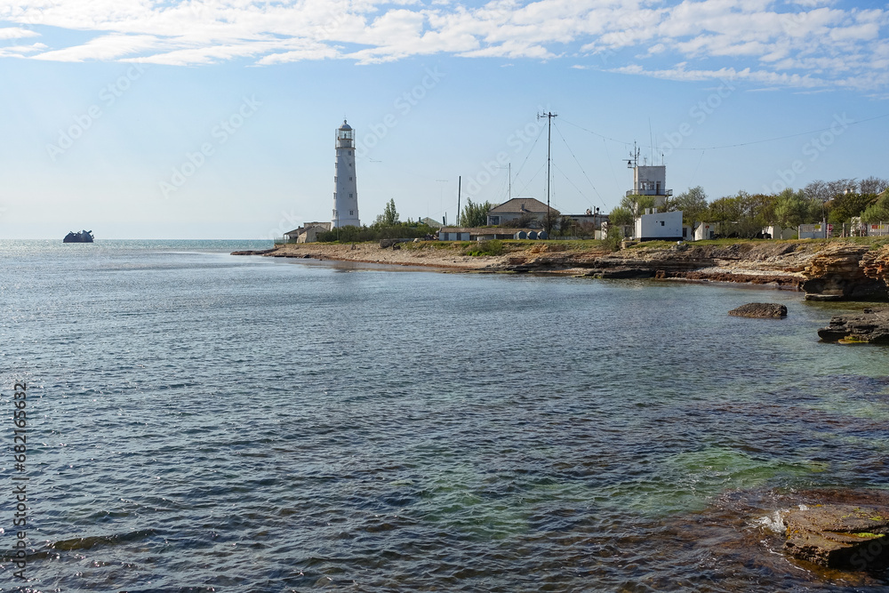 Lighthouse on Cape Tarkhankut. The rocky coast of the Dzhangul Reserve in the Crimea. Turquoise sea water. Tarkhankutsky lighthouse on the Crimean peninsula.