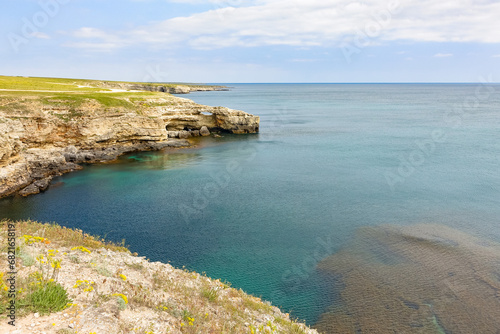 Cape Tarkhankut on the Crimean peninsula. The rocky coast of the Dzhangul Reserve in the Crimea. The Black Sea. Turquoise sea water. Rocks and grottoes of Cape Tarkhankut.