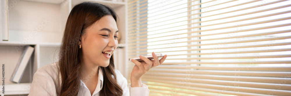 Naklejka premium Woman working at home, Attractive woman chatting or talking with colleague on mobile phone at her home, Work for home, Remote conversation or meeting , Stay home, Use a cell phone or smartphone.