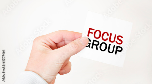 Businessman holding a card with text FOCUS GROUP , business concept