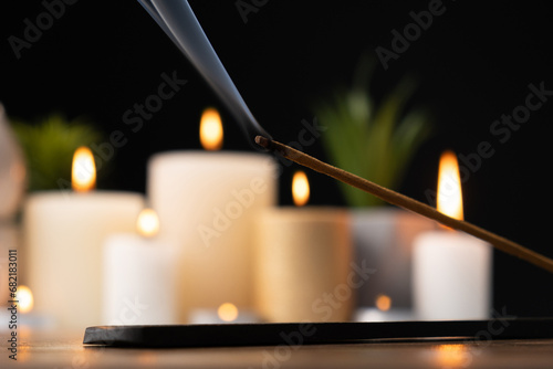 Incense stick on black and wooden background, incense smoke, for meditation and aromatherapy.