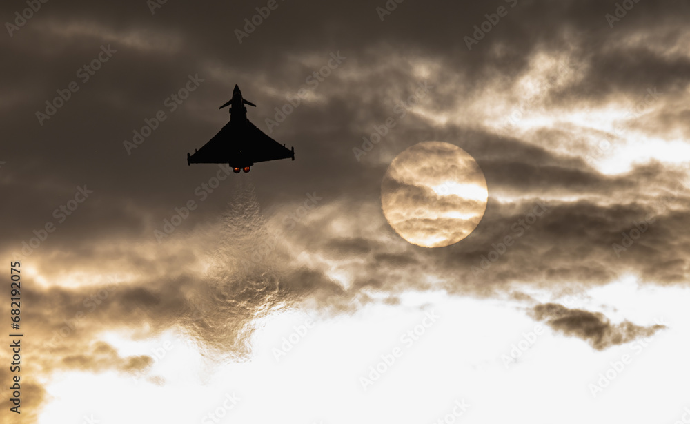 Samolot wojskowy na tle słońca - obrazy, fototapety, plakaty 