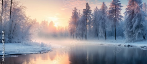 As the winter sun rose, illuminating the picturesque landscape, the vibrant blue sky reflected off the icy river, creating a stunning natural canvas for the tall trees in the European forest.