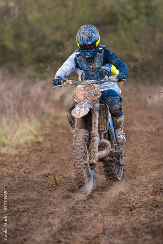 Une motocross de face sur un terrain boueux