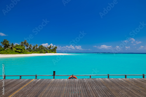 Summer beautiful landscape, nature of tropical beach with wooden platform, sunlight. White sand beach palm trees bright sea water and sunny blue sky. Copy space summer vacation destination concept © icemanphotos