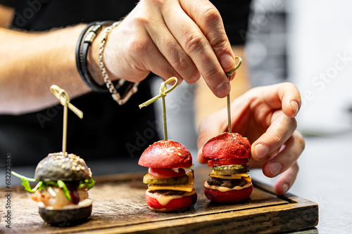 chef hand cooking set mini hamburgers, mini burgers on restaurant kitchen photo