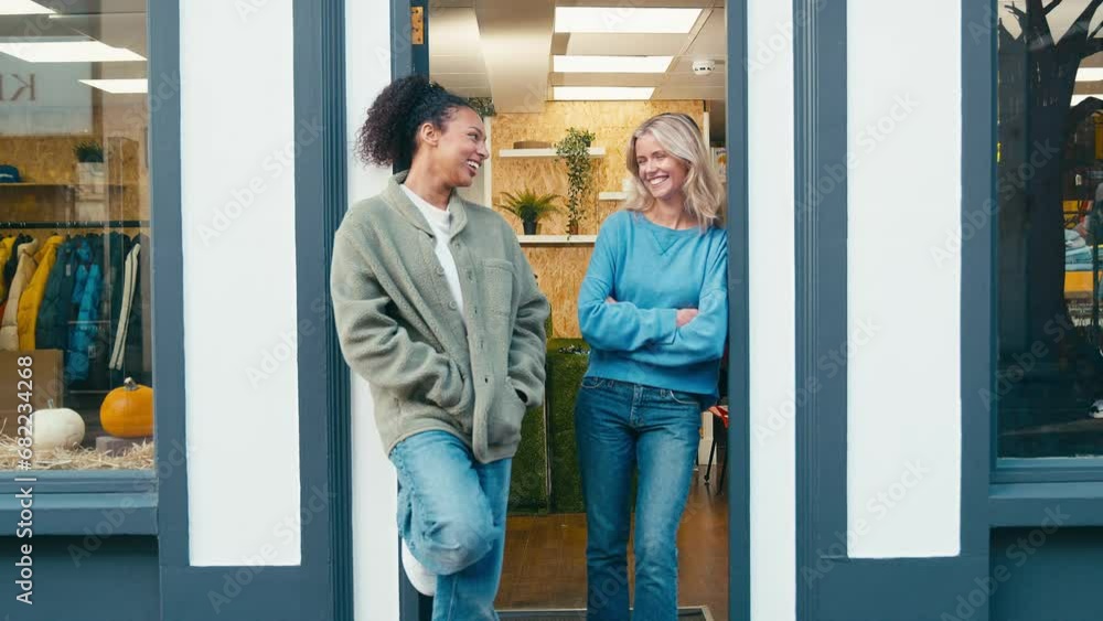 Portrait of smiling female staff and owner standing outside in entrance to fashion or clothes store - shot in slow motion Portrait of smiling female staff and owner standing outside in entrance to fashion or clothes store - shot in slow motion