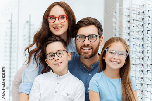 Happy family choosing eyeglasses frames in optical shop