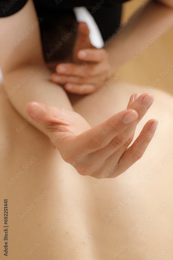 Naklejka premium Young woman receiving a back massage in a spa center.