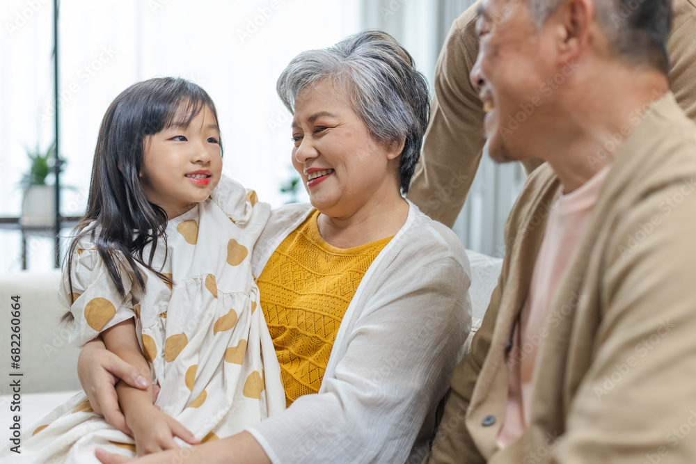 Happy Family Grandfather Grandmother and Granddaughter having fun living room at home. connects relationships different ages. Relax Time children with parents, Family Happiness Concept.