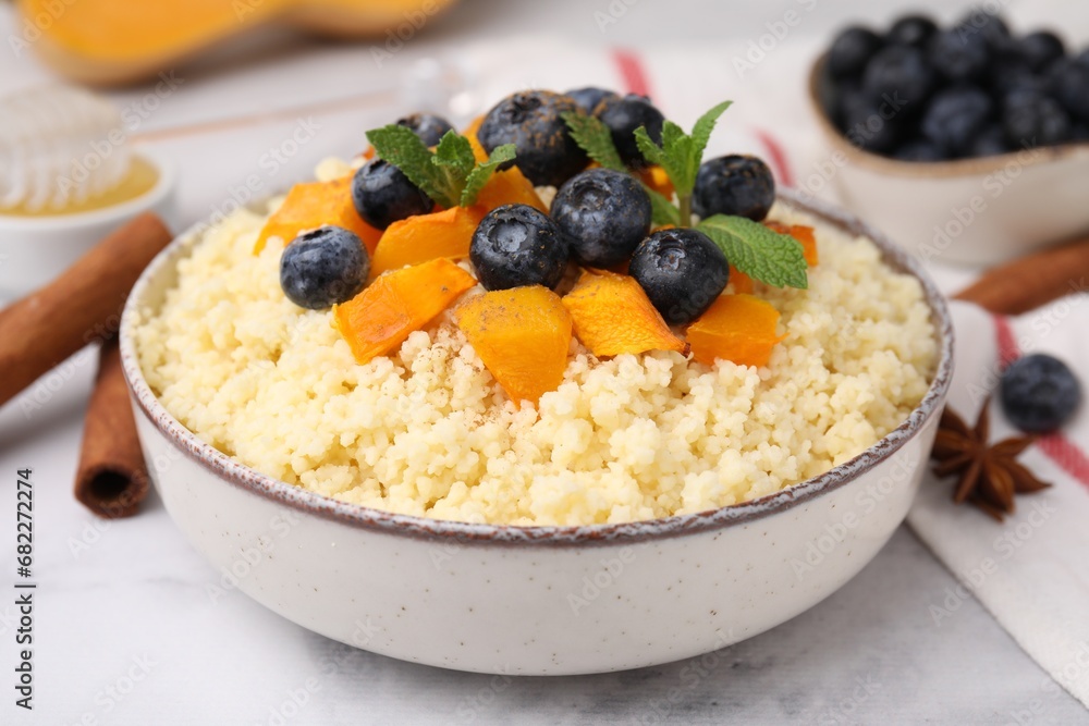 Bowl of tasty couscous with blueberries, pumpkin and mint on table, closeup Bowl of tasty couscous with blueberries, pumpkin and mint on table, closeup