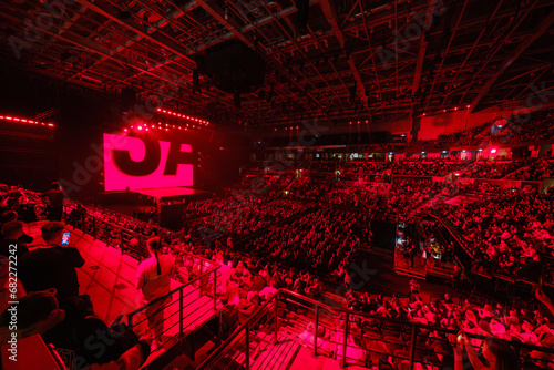 Aerial view of business crowd enjoying concert in large illuminated red stadium photo