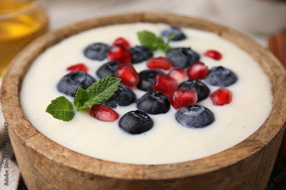 Bowl of delicious semolina pudding with blueberries, pomegranate and mint, closeup Bowl of delicious semolina pudding with blueberries, pomegranate and mint, closeup