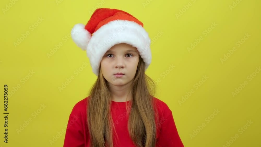 New year baby portrait, little girl isolated on yellow background showing emotions New year baby portrait, little girl isolated on yellow background showing emotions