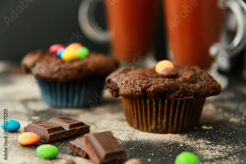 Chocolate muffins. Sweet dark cookies with chocolate and cocoa powder. Homemade, freshly baked delicious cupcakes on the dark background