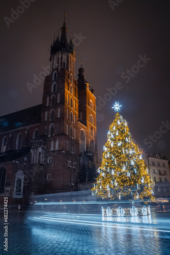 Kraków nocą w Święta Bożego Narodzenia z choinką świąteczną koło kościoła| Cracov by night ny Christmas withe the christmas tree next to church photo