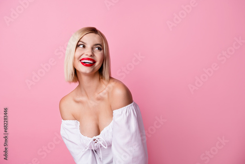 Photo of cute cheerful girl dressed white trendy clothes looking up empty space banner isolated on pink color background photo