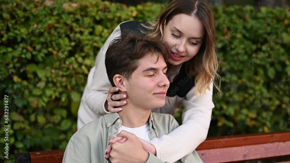 Manifestation of love and tenderness of a young couple on a park bench. Slow motion Manifestation of love and tenderness of a young couple on a park bench. Slow motion