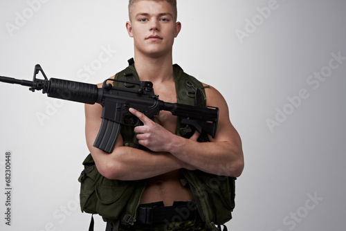 Soldier man, vest and rifle in studio portrait for military service, fight and fitness by white background. Army agent, government employee and bodybuilder in tactical clothes for battle, war and gun