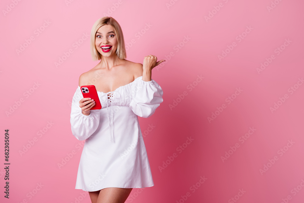 Photo of cute excited girl dressed white outfit texting apple samsung iphone device thumb empty space isolated pink color background Photo of cute excited girl dressed white outfit texting apple samsung iphone device thumb empty space isolated pink color background