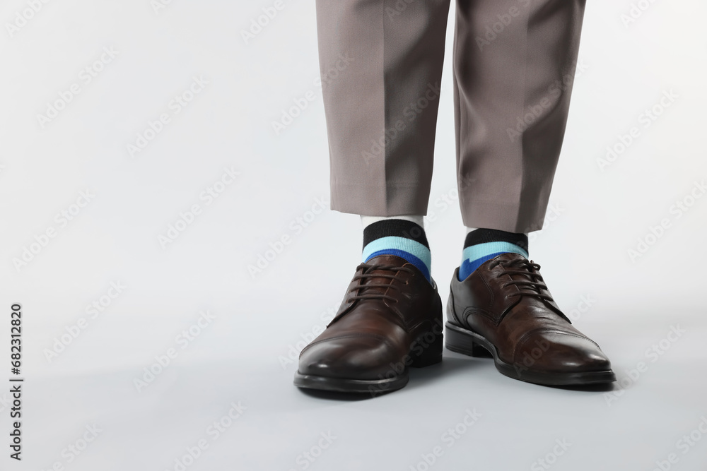 Man in stylish colorful socks, shoes and pants on white background, closeup. Space for text Man in stylish colorful socks, shoes and pants on white background, closeup. Space for text