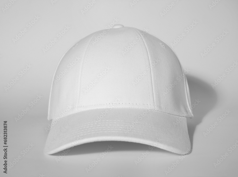 Stylish white baseball cap on light background Stylish white baseball cap on light background