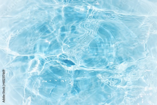 Blue water with ripples on the surface. Defocus blurred transparent white-black colored clear calm water surface texture with splash and bubbles. Water waves with shining pattern texture background.