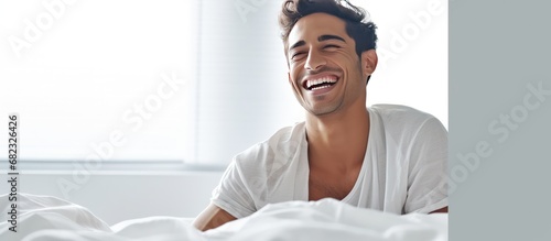 Handsome Happy Young Guy Waking Up In The Morning, Sitting On Bed And Stretching After Good Sleep,