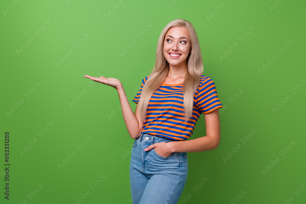 Photo of lovely cute girl wear stylish clothes arm hold novelty product new collection empty space isolated on green color background Photo of lovely cute girl wear stylish clothes arm hold novelty product new collection empty space isolated on green color background