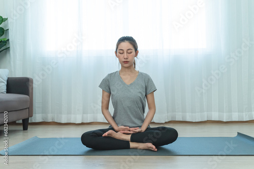 Yoga and meditation lifestyles. close up view of young beautiful woman practicing yoga namaste pose in the living room at home.