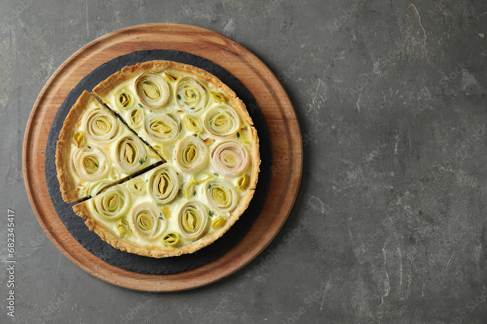 Tasty leek pie on dark textured table, top view. Space for text