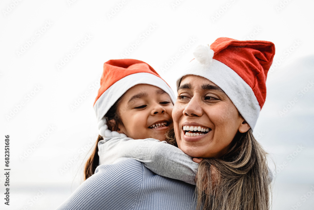 Happy Latina mother and child daughter having fun in Christmas time outdoor. Family love relationship Happy Latina mother and child daughter having fun in Christmas time outdoor. Family love relationship
