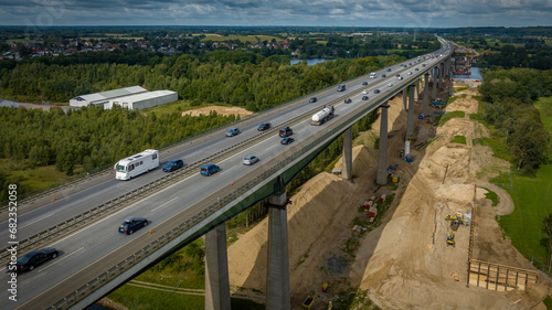 Aerial view of bridge replacement construction. The Rader high bridge that spans the Kiel Canal under replacement construction. The bridge replacement. Construction vehicle on construction site.  photo
