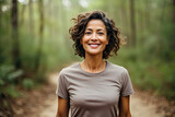 Happy middle-aged woman enjoying nature on a forest trail suitable for marketing campaigns promoting wellness and outdoor activities