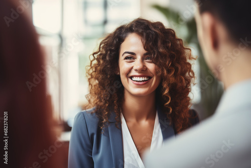 Éxito Compartido: Mujer Joven Radiante en una Reunión de Trabajo Feliz