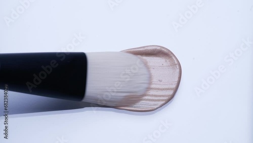 Liquid highlighter spread with white brush on white background