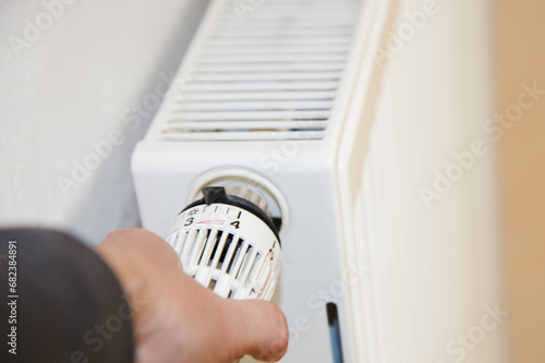 hand with radiator. Hand regulation Close-up of the heating thermostat with radiator in Germany. Temperature Of Radiator Thermostat photo
