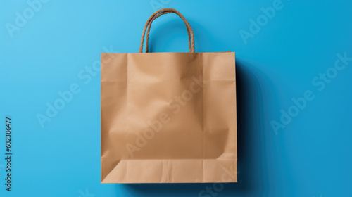 Plain brown paper shopping bag with a twisted rope handle, set against a bright blue background.