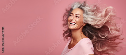 Beautiful, gorgeous 50s mid age beautiful elderly senior model woman laughing and smiling. Close up portrait. Healthy face skin care beauty. Isolated on pink background.