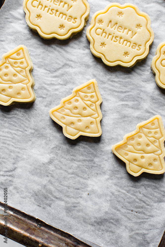 Top view of cut out raw sugar cookie dough for christmas, Christmas sugar cookie dough about to be baked, process of making xmas sugar cookies Top view of cut out raw sugar cookie dough for christmas, Christmas sugar cookie dough about to be baked, process of making xmas sugar cookies