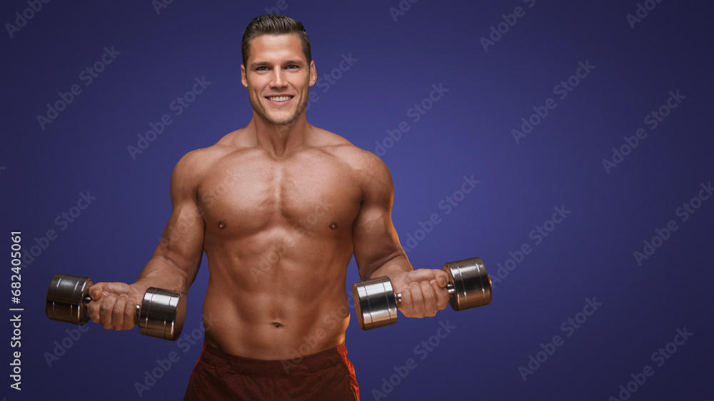 Confident male model holding dumbbells on a purple background