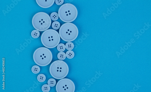 Background of blue fabric with blue buttons of different sizes