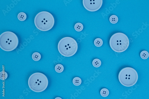 Blue buttons of different sizes on a background of blue fabric © Valeria F