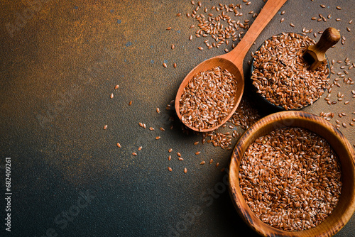 Wooden spoon with flax seeds, on a dark background. Organic food, superfood. Top view. photo