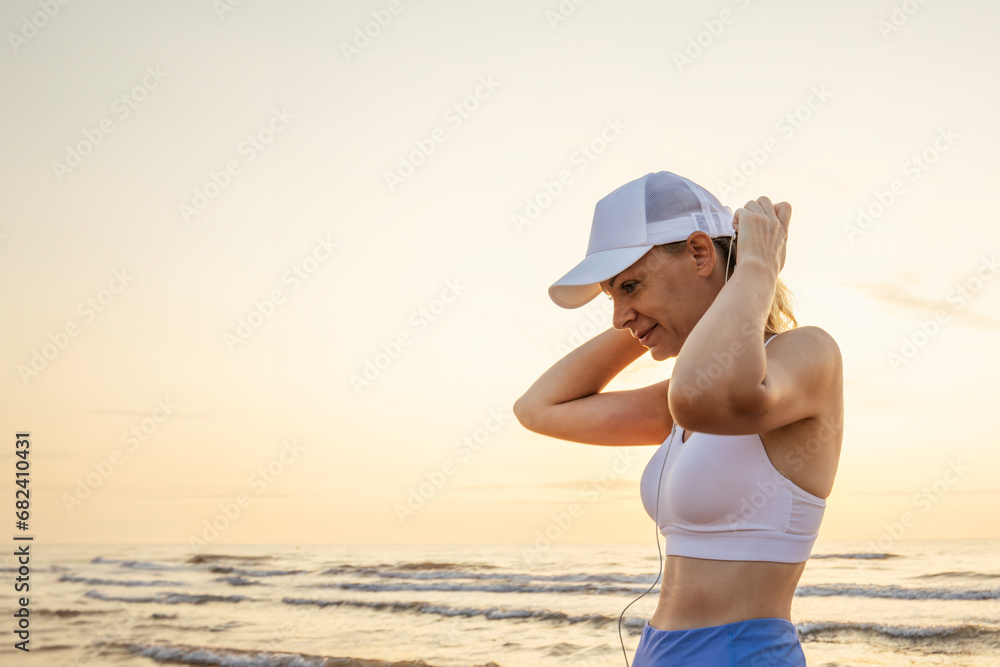 portrait of an attractive young woman running along the beach and listening to music on headphones. portrait of an attractive young woman running along the beach and listening to music on headphones.