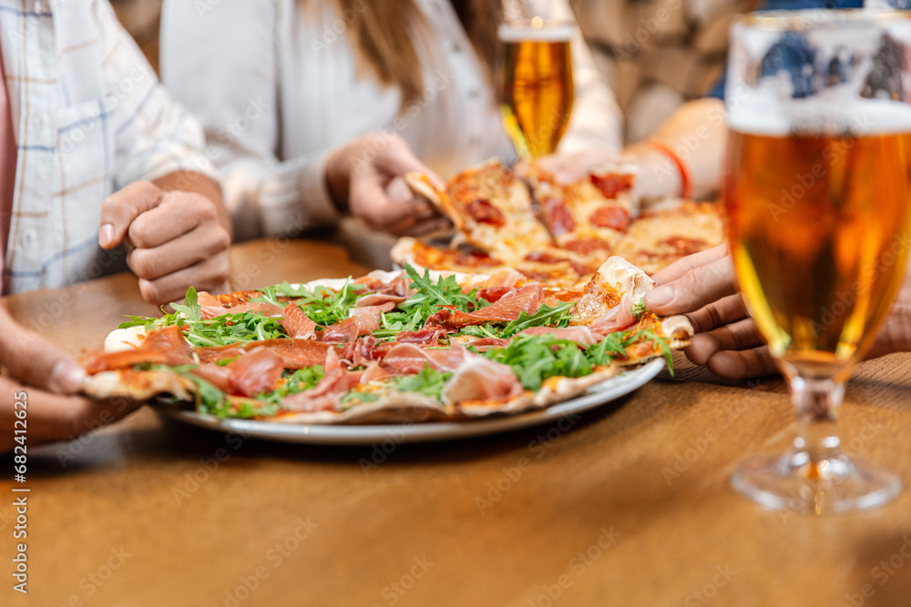 leisure, food and drinks, people and holidays concept - close up of friends eating pizza and drinking beer at restaurant or pub leisure, food and drinks, people and holidays concept - close up of friends eating pizza and drinking beer at restaurant or pub