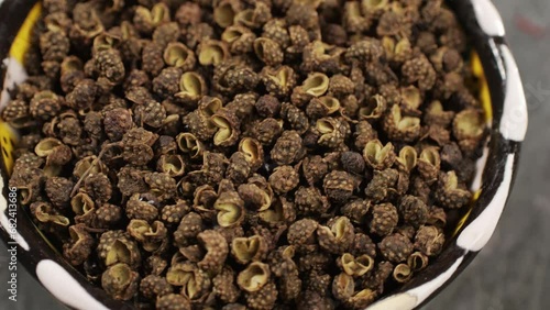 Dried black pepper rotating top view. A bunch of natural black pepper peas hot spice.Seasonings and condiments concept photo