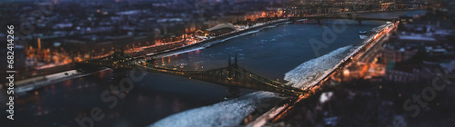 The magic panorama of the city at dusk, river, two bridge and city lights. Budapest Hungary, tilt-shift effect, toned