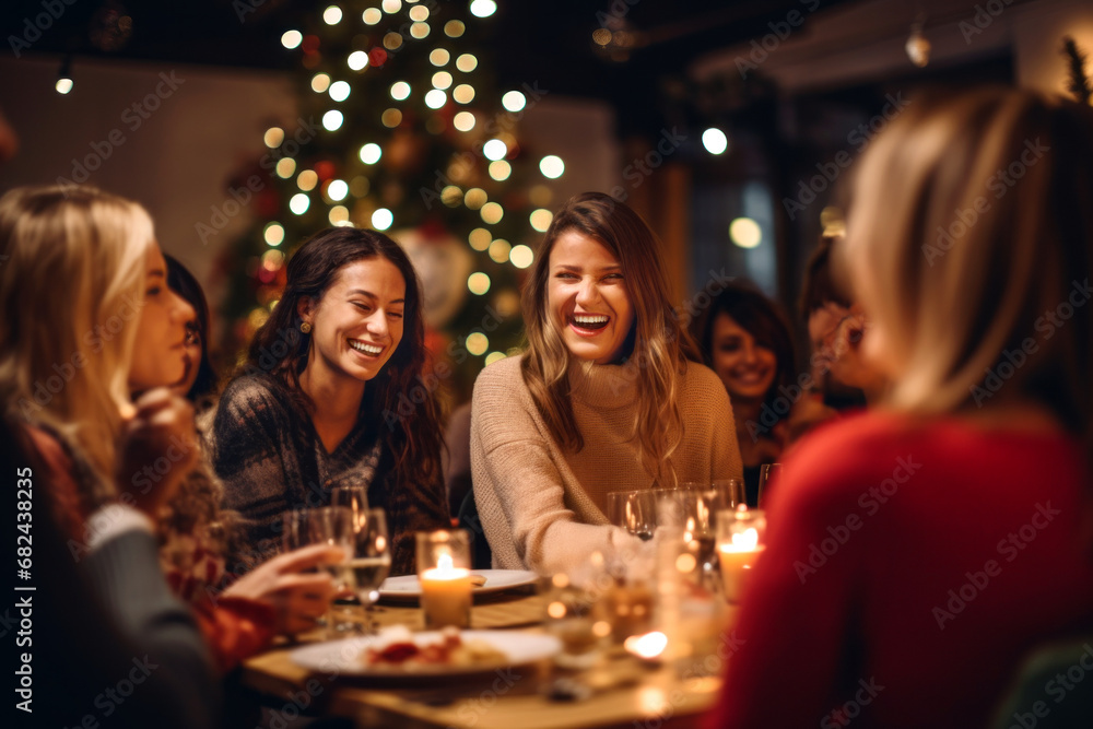 Group of cheerful friends having fun eating Christmas dinner together by decorated table. Young people having a get together on winter night. - obrazy, fototapety, plakaty 